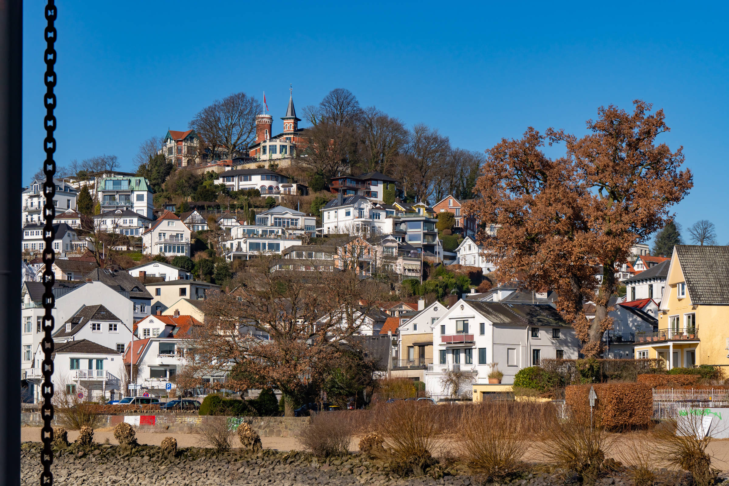 Das Treppenviertel in Blankenese Hamburg bei blauem Himmel vom Elbstrand aus fotografiert als Teil einer Immobilenfotografie Strecke.