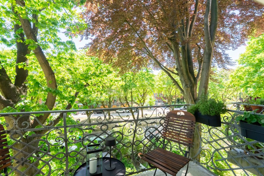 Immobilienfotografie Hamburg, Blick von einem Altbau-Balkon nach draußen auf eine Allee